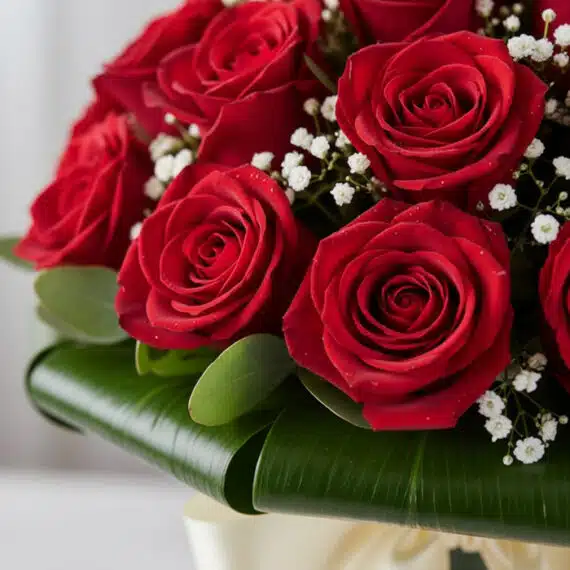 Primer plano extremo de un arreglo floral DOMENICA con 30 rosas rojas vibrantes, gotas de rocío sutiles y follaje verde, dest