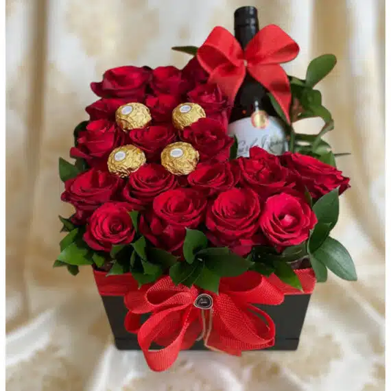 Arreglo Floral ENRICO: Rosas Rojas, Vino y Chocolates para Regalo Arreglo floral ENRICO con rosas rojas frescas, botella de vino tinto y chocolates Ferrero Rocher, presentado en una caja negr