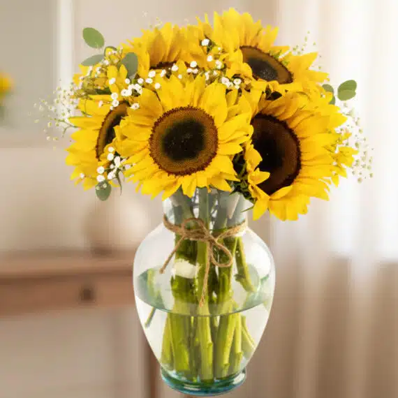 Arreglo Floral LILA con Girasoles: Un Regalo Radiante de Amor y Gratitud 🌻 Arreglo floral de girasoles vibrantes en un jarrón de cristal transparente con lazo de yute, sobre un fondo elegante y suavem