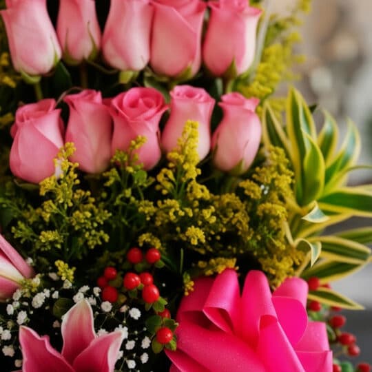 Primer plano extremo de Arreglo Floral Quiero que Sepas, mostrando rosas rosadas, lirios, bayas rojas y follaje verde con got