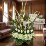 Arreglo floral fúnebre 'Eterno Descanso' con lirios, rosas blancas e hortensias, en una sala de velación premium con luz natu