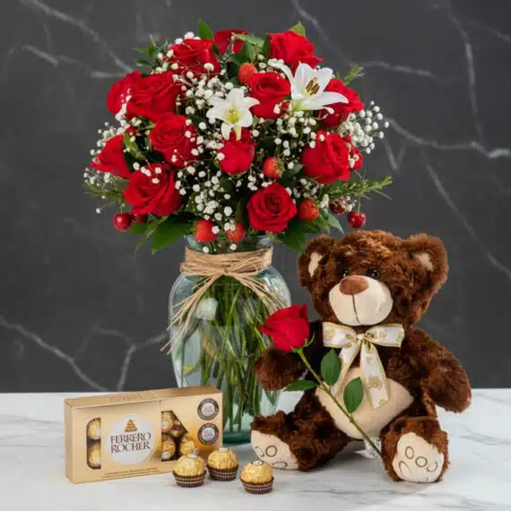 Jarrón Todo Para Ti: Rosas Rojas, Lirios y Osito de Peluche Jarrón Todo Para Ti con rosas rojas, lirios blancos, fresas, cerezas, osito de peluche con rosa y caja de bombones Ferrero Ro